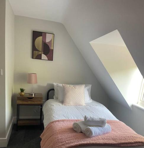 a bedroom with a bed with two towels on it at Poplar House by ShortStays4U 2Bedroom house in town centre with free Parking! in King's Lynn