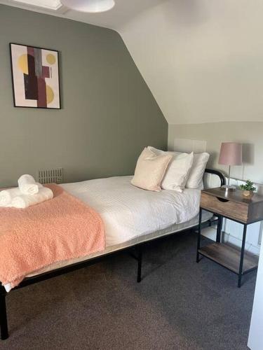 a bedroom with a bed and a side table at Poplar House by ShortStays4U 2Bedroom house in town centre with free Parking! in King's Lynn