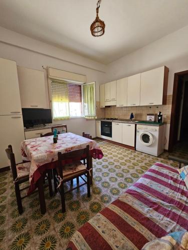 a kitchen with a table and two chairs in a room at Sunset beach in Cefalù