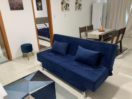 Sofá azul en la sala de estar con mesa en Novíssimo apto no melhor de São Lourenço, en São Lourenço