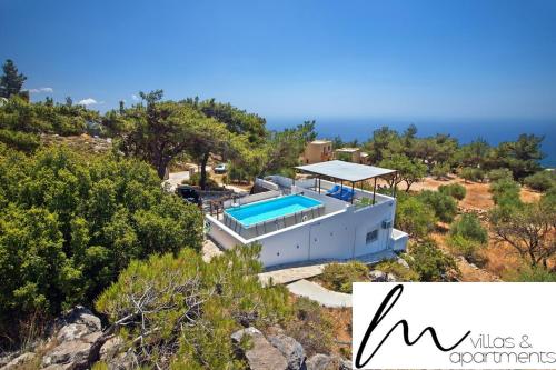 Villa M - Villa with private pool and yard في Anatolí: اطلالة جوية على منزل مع مسبح