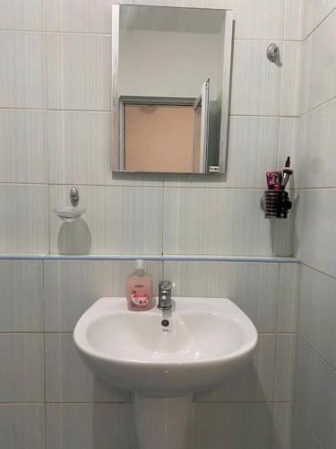 a white sink in a bathroom with a mirror at Pomorie Direkt am Pool in Pomorie