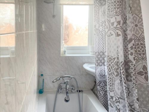 uma casa de banho com uma banheira, um lavatório e uma cortina de chuveiro em Sandancer em South Shields