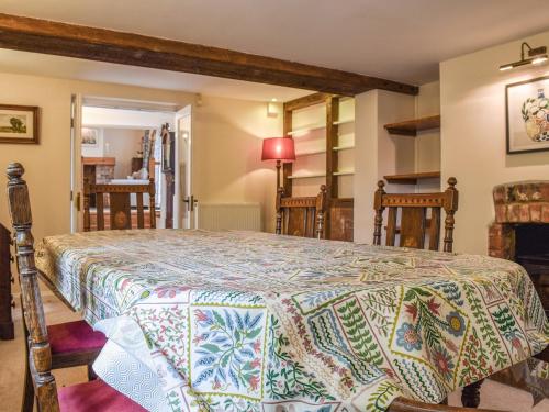 1 dormitorio con 1 cama con edredón en Wayside Cottage en Adstock