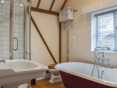 La salle de bains est pourvue d'une baignoire, d'un lavabo et de toilettes. dans l'établissement Wayside Cottage, à Adstock