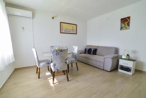 a living room with a table and chairs and a couch at Apartman Noa in Hrvace