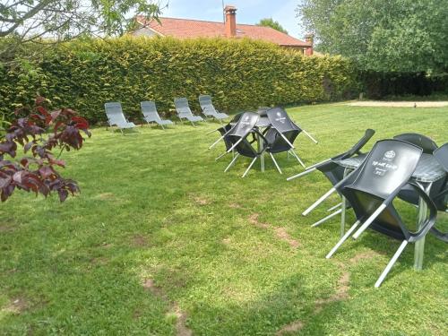a group of chairs and tables in the grass at Pension Xacobeo Lavacolla in Lavacolla
