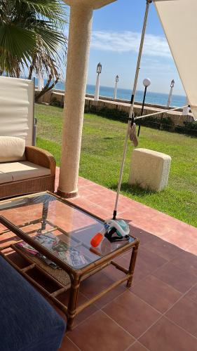 a glass table with a mop sitting on a patio at IBAIA maison d'hôte in Fnidek