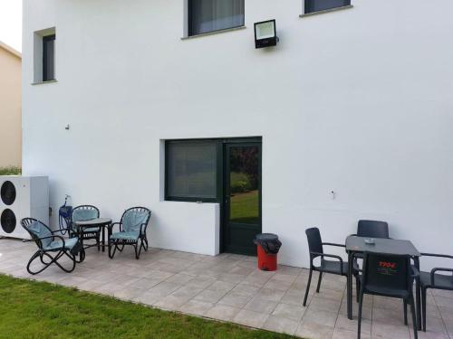 a patio with tables and chairs next to a white building at Pension Xacobeo Lavacolla in Lavacolla