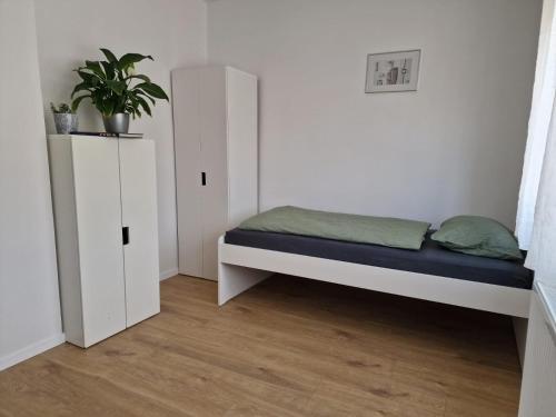sypialnia z łóżkiem, szafką i rośliną w obiekcie Apartment Lori w mieście Matulji