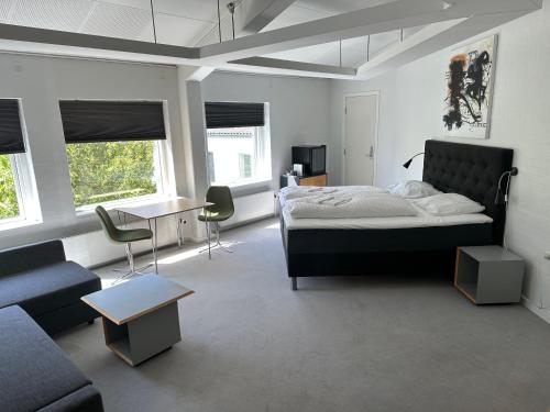 Løgstør Parkhotel في Løgstør: غرفة نوم بسرير واريكة وطاولة