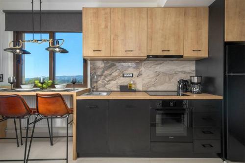 a kitchen with black appliances and wooden cabinets at MENTA lux apartment sea view in Asgourou