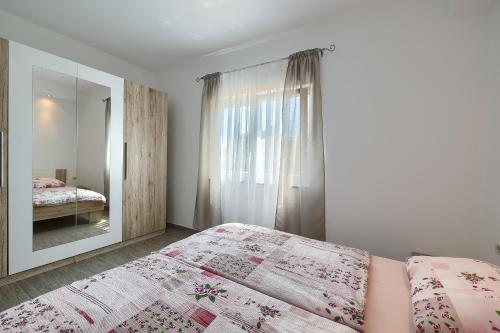 een slaapkamer met een bed en een spiegel bij Apartman Mishel 1 Fazana in Fažana