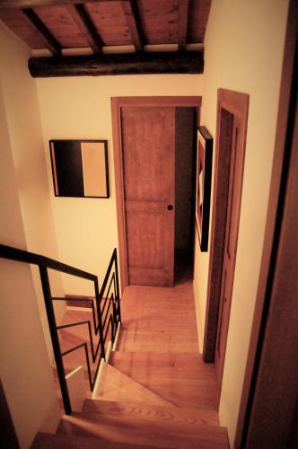 a hallway with a stairway with a wooden door at Il Sanco in Selva di Progno
