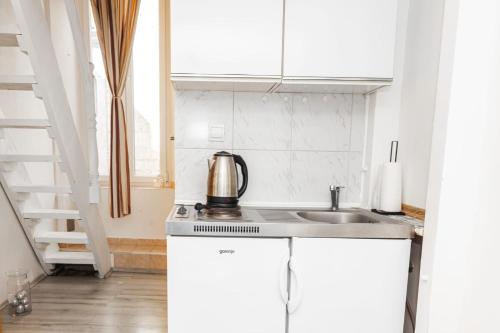 a white kitchen with a sink and a staircase at Heart of Dubrovnik Old Town apartments in Dubrovnik