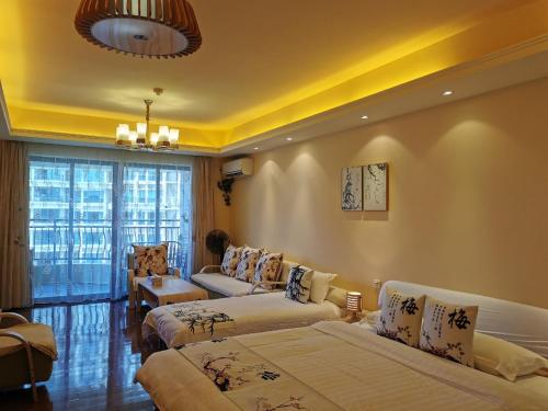 The Silver Beach Country Garden Apartment في Huidong: غرفة معيشة بها سريرين وأريكة