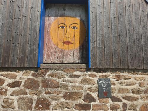 een deur met een schilderij van een gezicht erop bij Ty Cœur in Bais