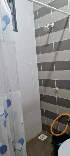 y baño con ducha y manguera. en DHut Homestay puncak iskandar, en Seri Iskandar