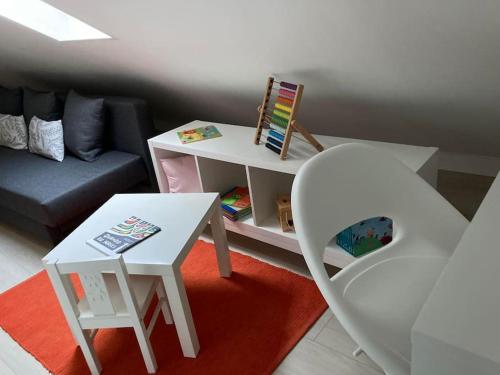 ein Wohnzimmer mit einem weißen Tisch und einem Stuhl in der Unterkunft Gafa House - Family Accommodation and Workplace in Gafanha da Nazaré