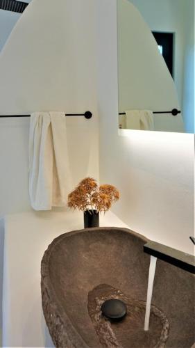 a bathroom with a wooden table and a mirror at Panormos Panorama in Mikonos