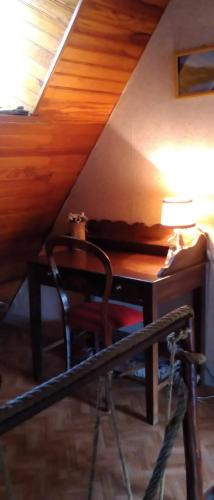 a desk with a lamp and a chair in a attic at Gîte de la Séoube in Campan