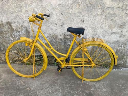 a yellow bike parked in front of a wall at Gafa House - Family Accommodation and Workplace in Gafanha da Nazaré