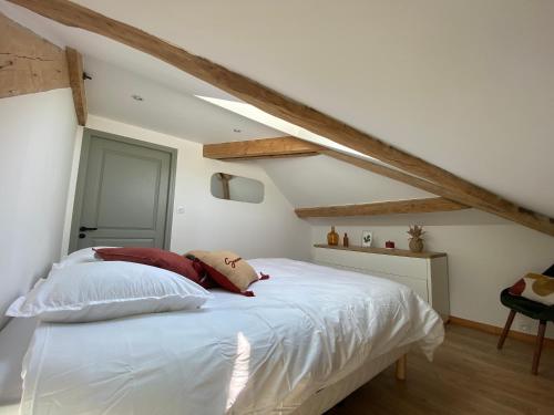 una camera da letto con letto bianco in mansarda di Appartement de charme au pied du Grand Colombier a Culoz