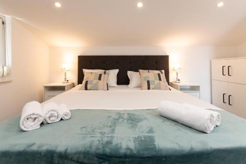 een slaapkamer met een groot bed en handdoeken bij Olivae Apartments in Trogir