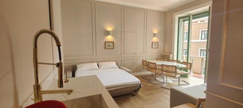 Cette chambre comprend un lit, une table et un lavabo. dans l'établissement Marcora 6 v luxury living, à Milan