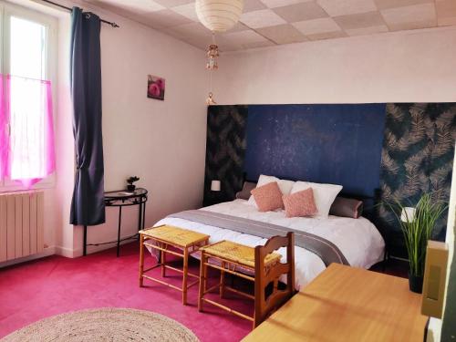 a bedroom with a large bed and a table at Les Bibasses in Aillas