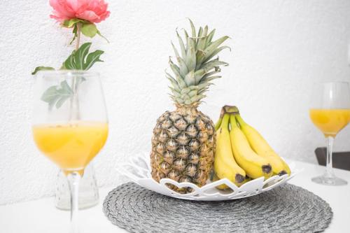 a plate of pineapple and bananas on a table with two glasses at Heart of Dubrovnik Old Town apartments in Dubrovnik