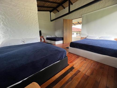 a bedroom with a large bed and a wooden floor at Caney 2 in Moniquirá