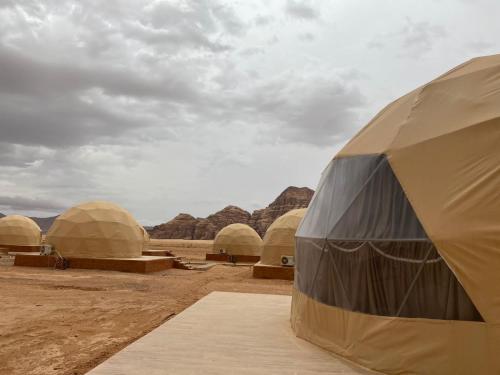 a group of domed tents in the desert at Al Rifi Luxury Camp in Wadi Rum