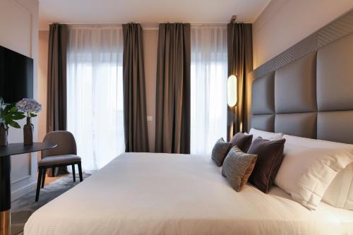 a bedroom with a large white bed and a desk at PRESTIGE BOUTIQUE APARTHOTEL - Piazza Duomo View in Milan