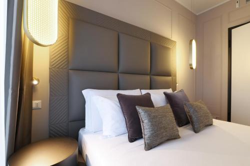 a bedroom with a large bed with pillows at PRESTIGE BOUTIQUE APARTHOTEL - Piazza Duomo View in Milan