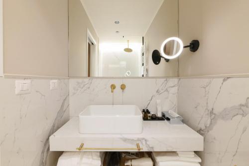 a bathroom with a white sink and a mirror at PRESTIGE BOUTIQUE APARTHOTEL - Piazza Duomo View in Milan