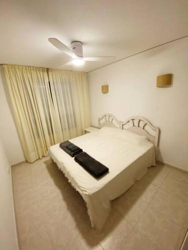 - une chambre avec un lit blanc et une couverture noire dans l'établissement Pueblo Mascarat, 50 m al mar, 3 piscios, à Altea la Vieja