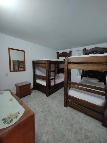 Cette chambre comprend 3 lits superposés et un miroir. dans l'établissement Villa Luciana, à Melgar