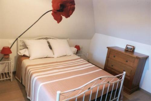1 dormitorio con 1 cama y 1 lámpara en la pared en Appart'Aubrac, 