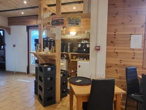 a table and chairs in a room with a wooden wall at Auberge La Coulette in Vars