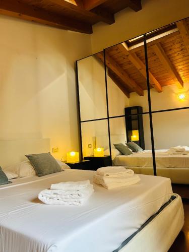two beds in a room with two mirrors at Vittoria Verona in Verona