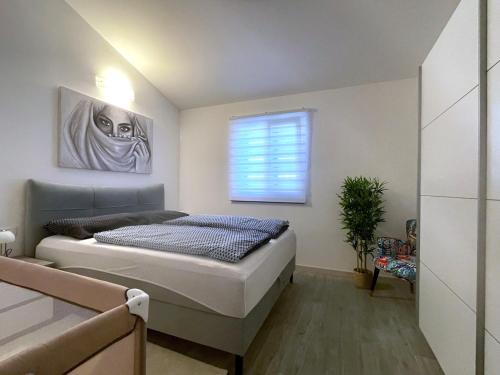 a bedroom with a bed and a window at Villa Dupini in Baška