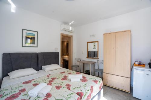 - une chambre avec un lit et des serviettes dans l'établissement Liana Studios, à Mykonos