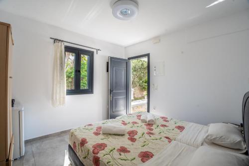 sypialnia z łóżkiem i oknem w obiekcie Liana Studios w mieście Mykonos