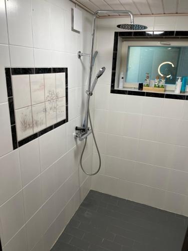 a shower in a white tiled bathroom at Big Duplex, 15min to Turku or Naantali in Turku