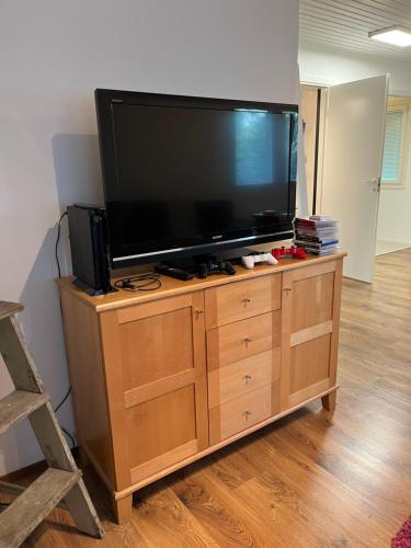 a large flat screen tv on a wooden entertainment center at Big Duplex, 15min to Turku or Naantali in Turku