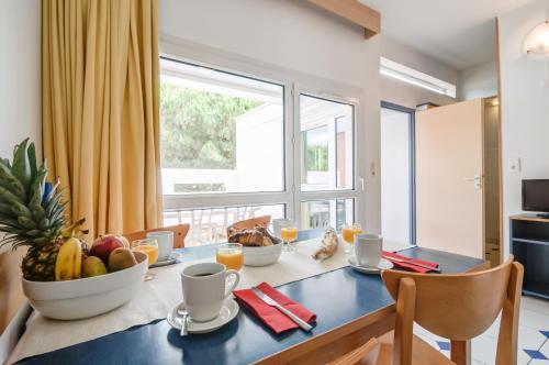 une salle à manger avec une table avec des fruits dessus dans l'établissement Résidence Pierre & Vacances Les Terrasses Du Parc, à La Grande Motte