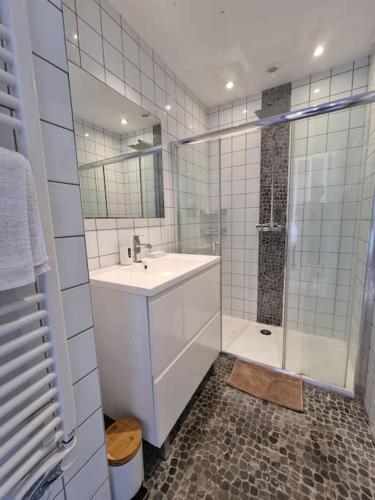 une salle de bain blanche avec un lavabo et une douche dans l'établissement Rare ! Magnifique appartement familial sur l'océan, à Lacanau-Océan