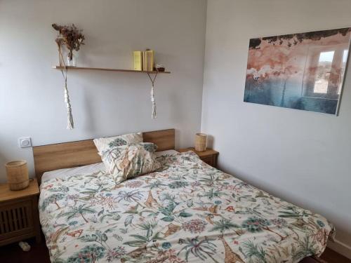 une chambre avec un lit avec une couette fleurie dans l'établissement Rare ! Magnifique appartement familial sur l'océan, à Lacanau-Océan