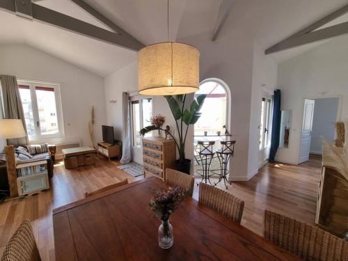un salon avec une table et des chaises et un salon dans l'établissement Rare ! Magnifique appartement familial sur l'océan, à Lacanau-Océan